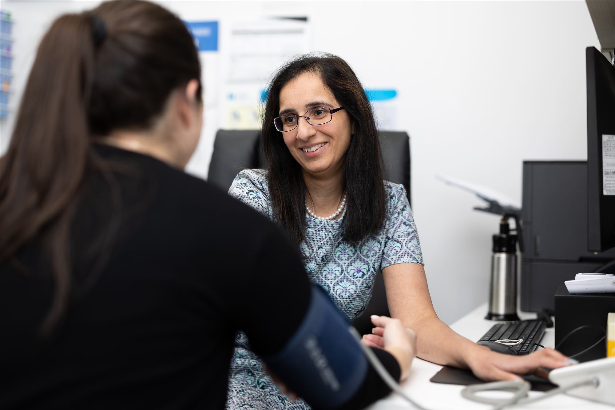 A Balwyn Central Medical GP smiling as she checks a patient's blood pressure