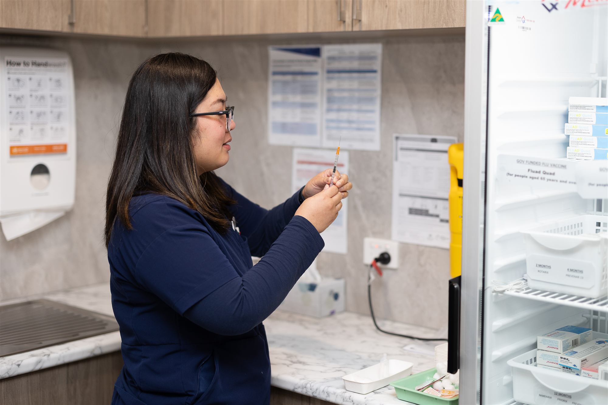 A practice nurse preparing a vaccine in the treatment room